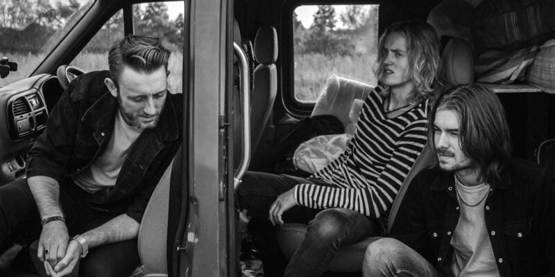 Four men sitting in the back of a van.