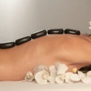 A woman getting a hot stone massage at a spa.