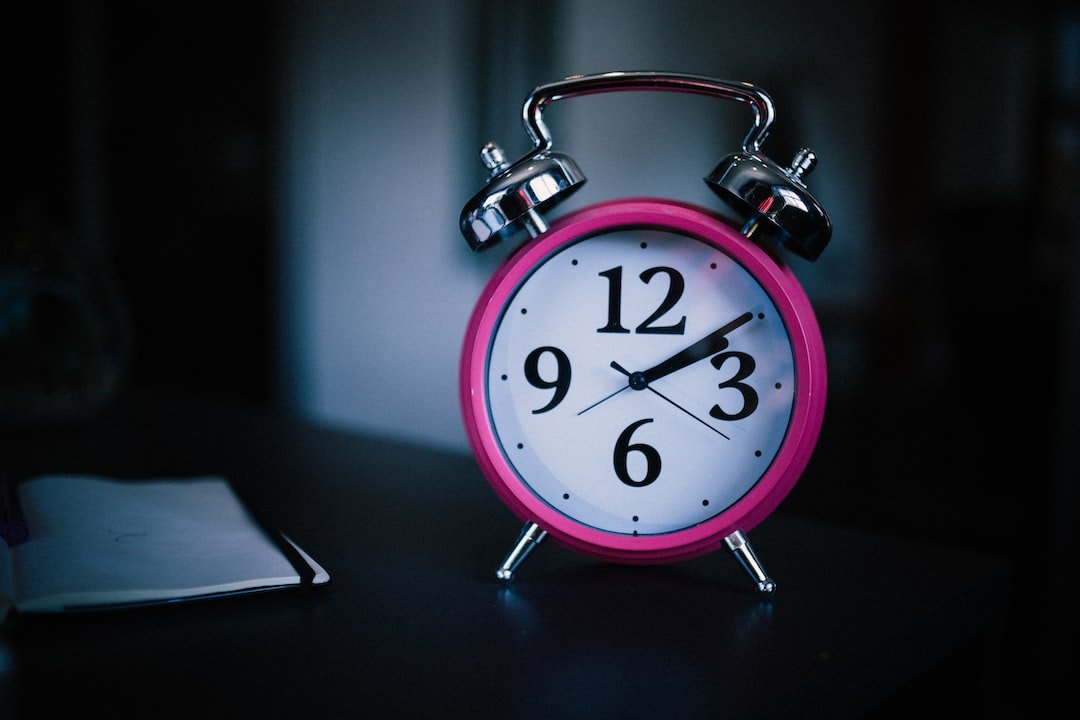 A pink alarm clock on a table.