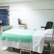 A hospital room with a bed and a chair.