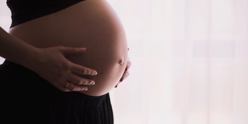 A pregnant woman holding her belly.