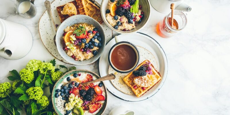 A table with plates of food and a cup of coffee.