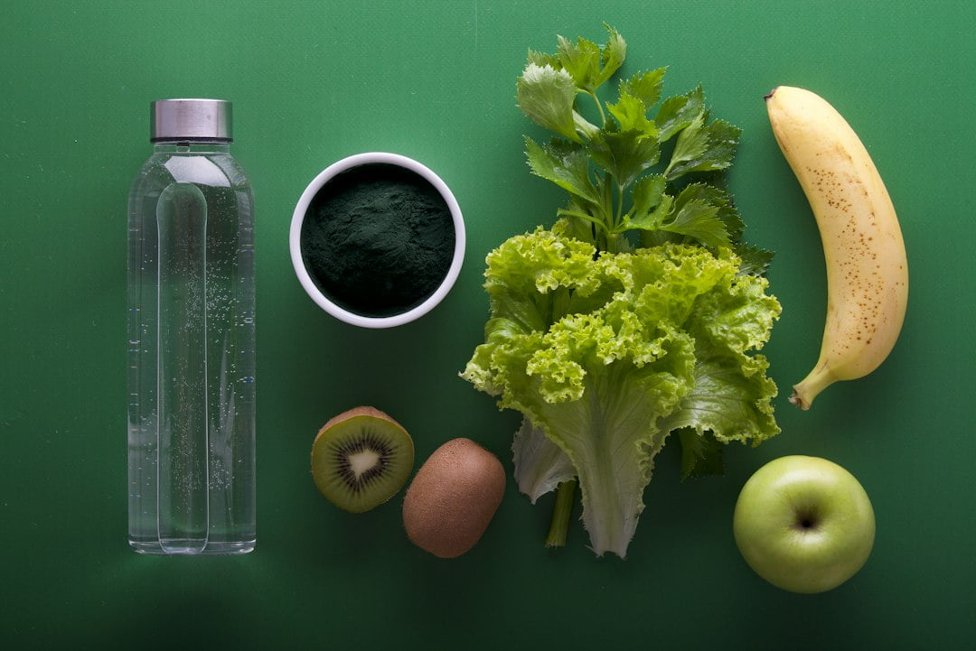 A group of fruits and vegetables on a green surface.