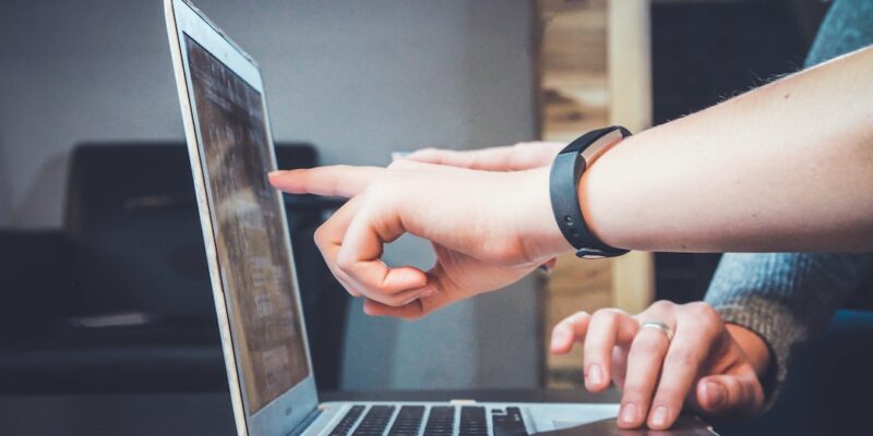 A person pointing at a laptop.