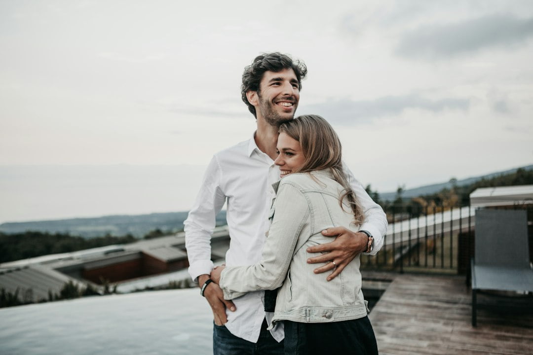 A man and woman hugging on a deck.