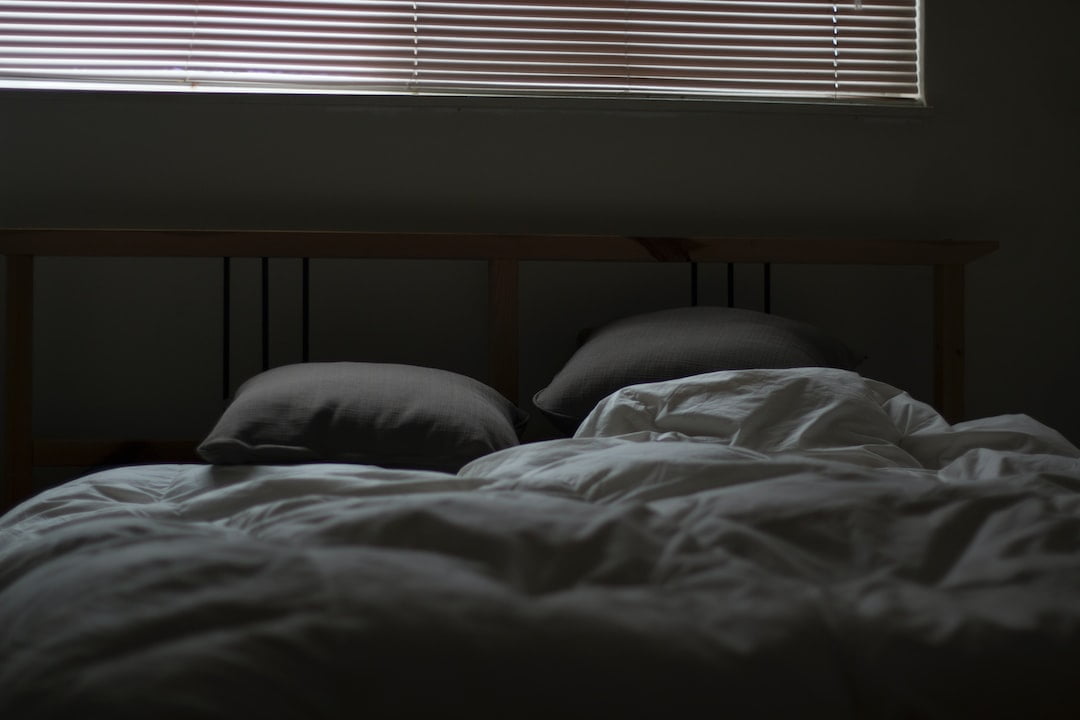 Pillows on a bed with a window.