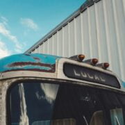 A blue bus parked in front of a building.