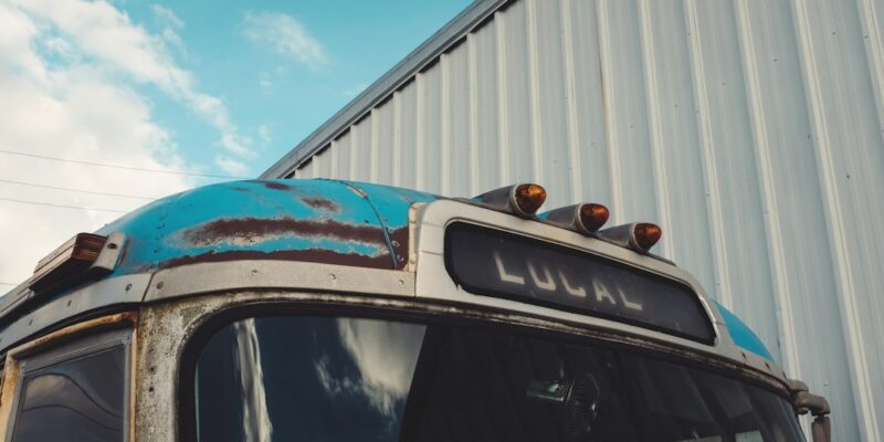 A blue bus parked in front of a building.