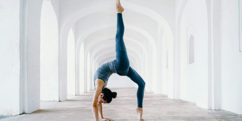 A woman doing a handstand in an empty hallway.