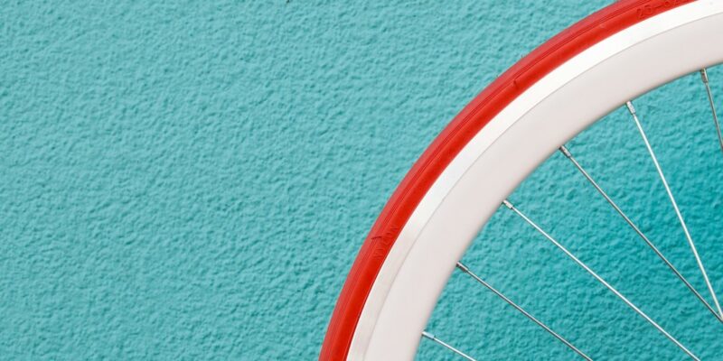 A bicycle wheel against a blue wall.