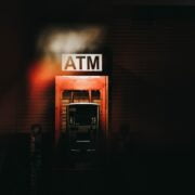 An atm sign in a dark building.