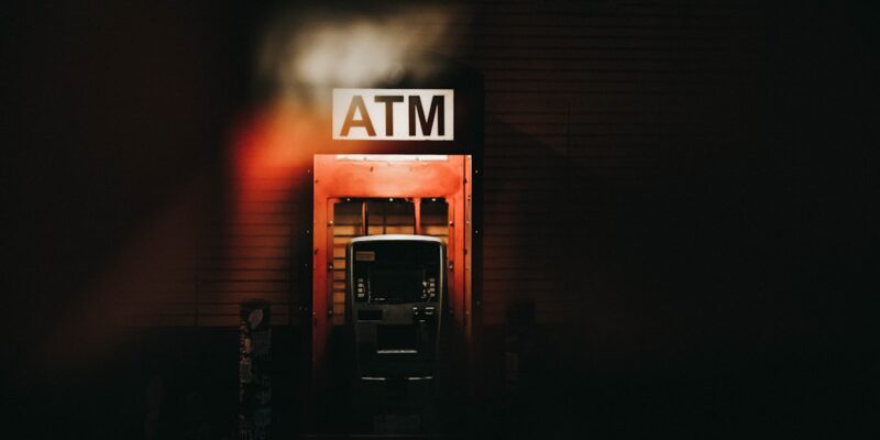 An atm sign in a dark building.