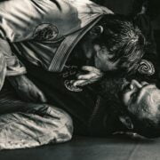 A black and white photo of two men in a jiu jitsu class.