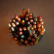 A group of colored pencils in a vase.