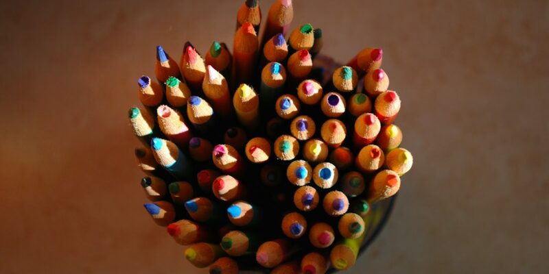 A group of colored pencils in a vase.