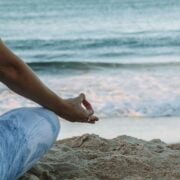 A woman meditating on the beach.