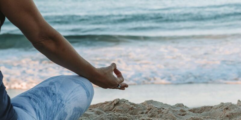 A woman meditating on the beach.