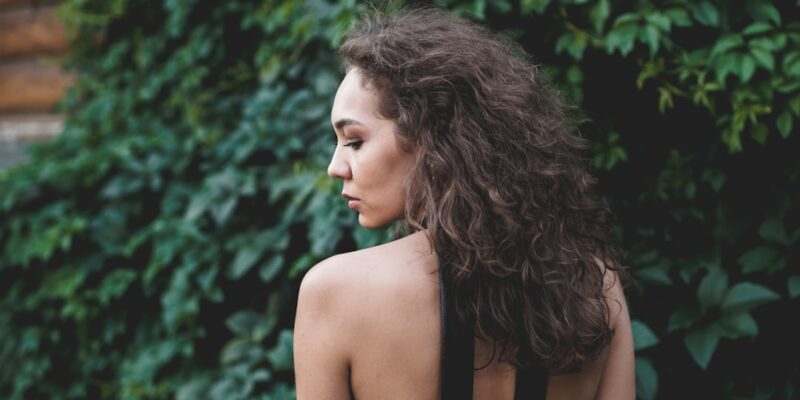 The back of a woman in a black dress.