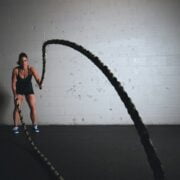 A woman is holding a rope in a gym.