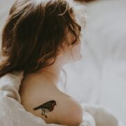 A girl with a mental health-related bird tattoo on her back.