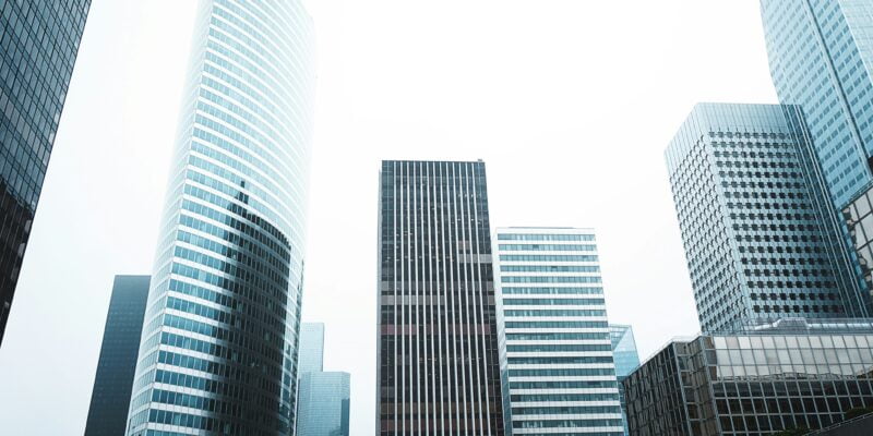 Modern skyscrapers reaching into an overcast sky in a bustling city's business district.