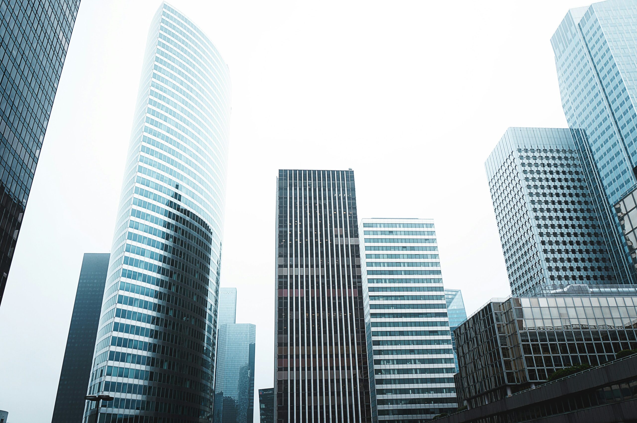 Modern skyscrapers reaching into an overcast sky in a bustling city's business district.