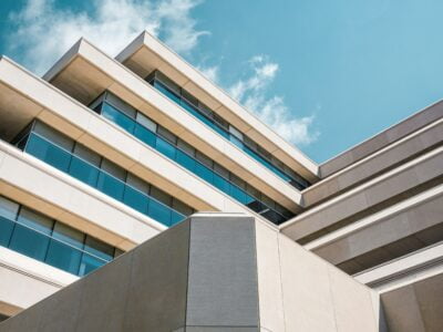 Modern architectural building with geometric design under a blue sky with clouds.