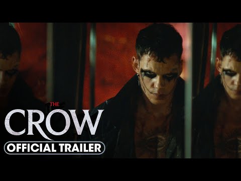 A person with dark eye makeup reflected in a broken mirror, with text overlay indicating "the crow official trailer: a tale of love and redemption.