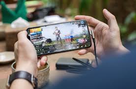 Person playing a mobile game on their smartphone with both hands.