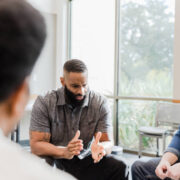 A group of men sitting around a table talking.