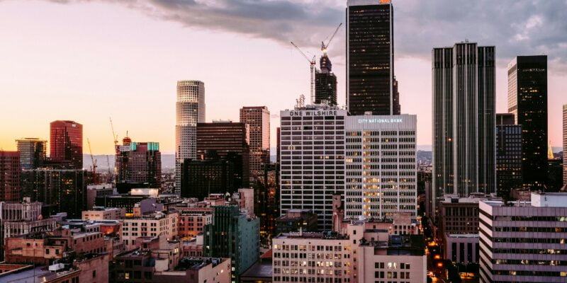 Downtown los angeles skyline at dusk with towering skyscrapers and a colorful sky.