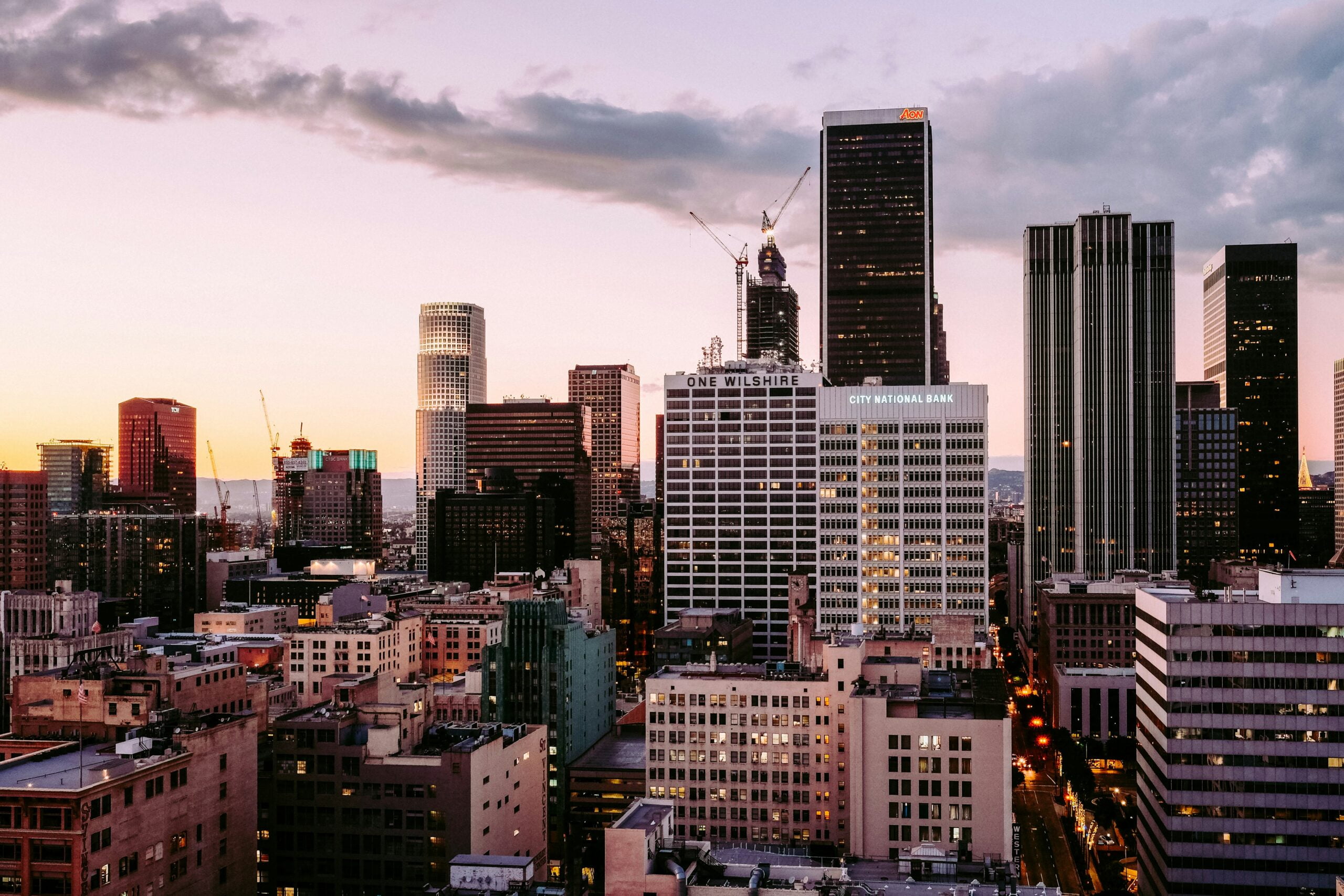 Downtown los angeles skyline at dusk with towering skyscrapers and a colorful sky.