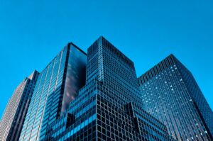 Modern glass skyscrapers against a clear blue sky, emblematic of Truman Press Publishing's commitment to protecting authors from scams and fraudulent practices.