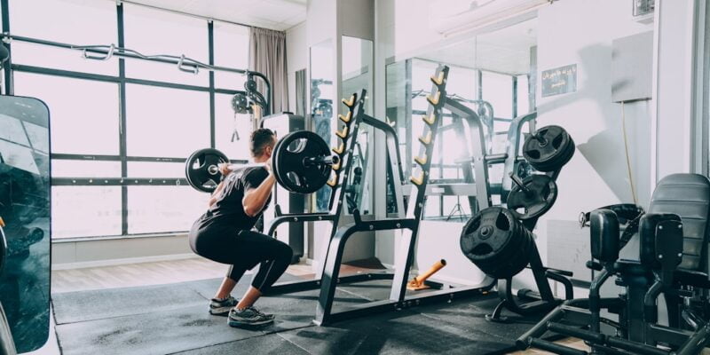 A man doing leg exercises in a gym in the morning.