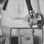 A black and white photo of a stethoscope hanging on a wall.