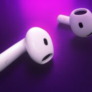 Two new white wireless earbuds, likely the Apple AirPods 4, are displayed against a purple background, with one earbud lying flat and the other tilted upright, promising an elevated sound experience.