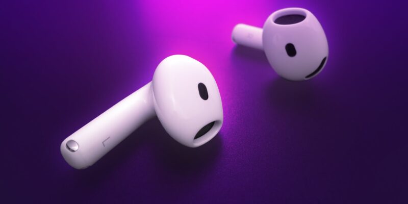 Two new white wireless earbuds, likely the Apple AirPods 4, are displayed against a purple background, with one earbud lying flat and the other tilted upright, promising an elevated sound experience.