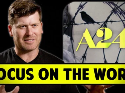 A person speaking next to a screen displaying a bird on barbed wire with "A24" text. The caption reads "Focus on the Work" in bold yellow.