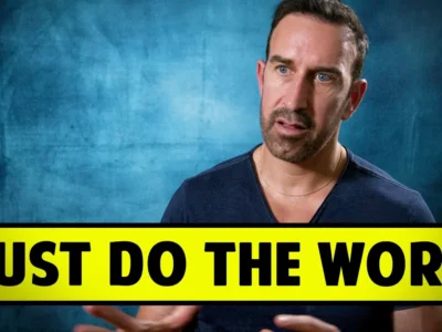 A person speaking in front of a blue backdrop, with a large caption reading "JUST DO THE WORK" in yellow and black.