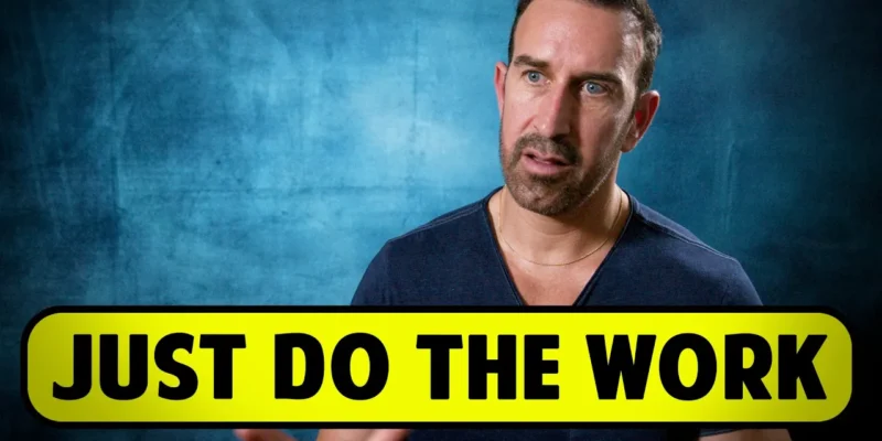 A person speaking in front of a blue backdrop, with a large caption reading "JUST DO THE WORK" in yellow and black.